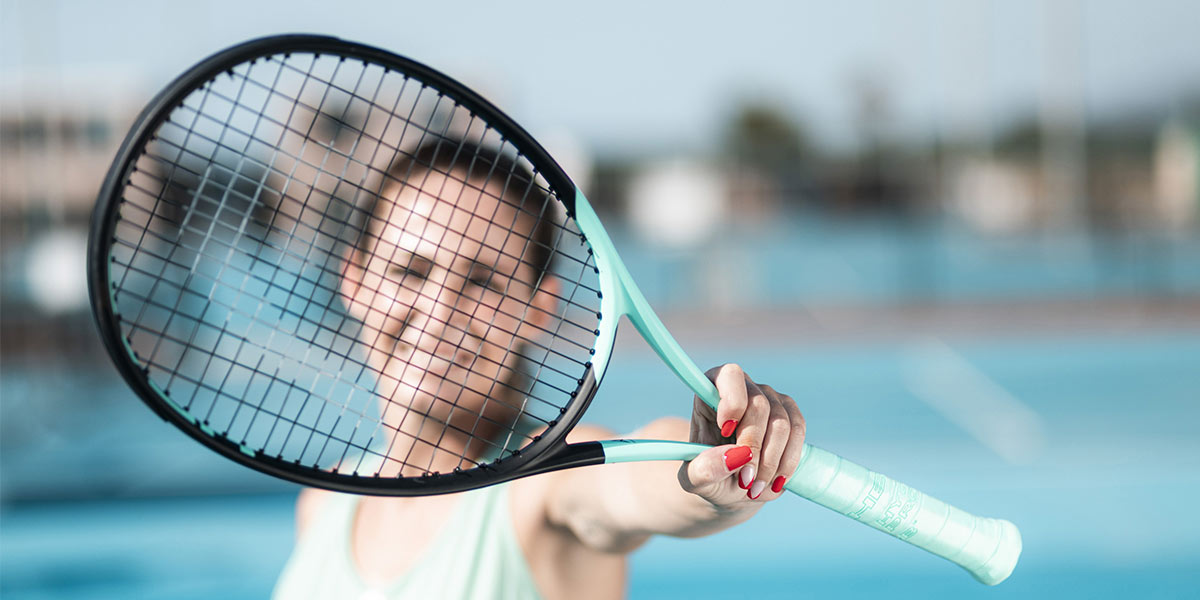 Woman holding the new BOOM tennis racket in her left hand